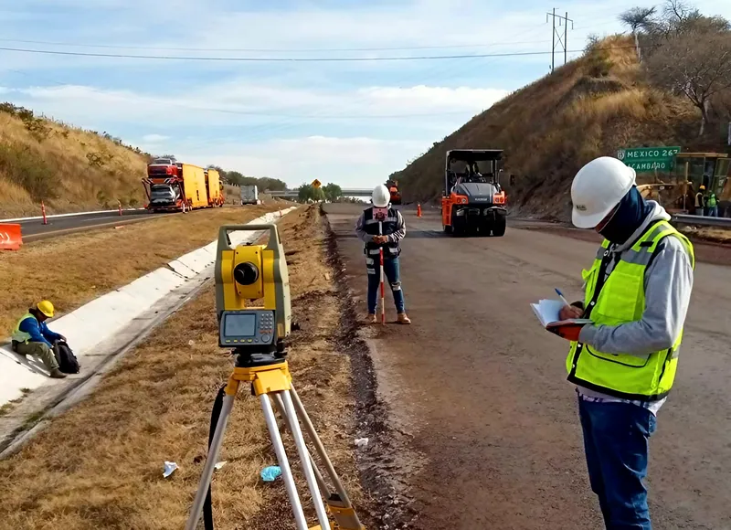 Estación total con brigada topográfica en obra carretera